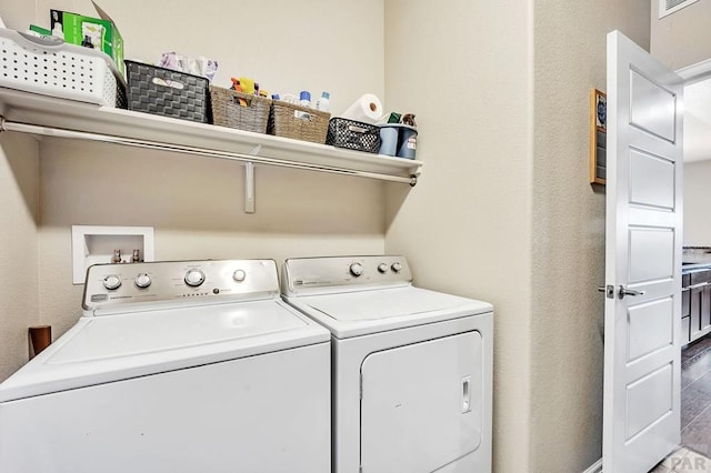 laundry area with laundry area, separate washer and dryer, wood finished floors, and visible vents