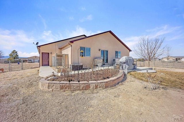 exterior space featuring a patio area, fence, and stucco siding