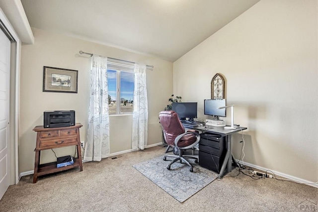 office space with baseboards, vaulted ceiling, and carpet flooring