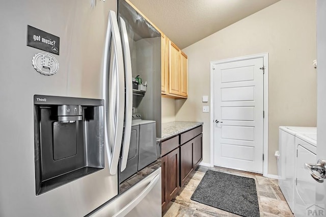 washroom with baseboards and independent washer and dryer