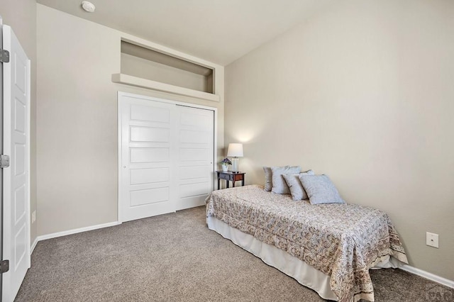 carpeted bedroom with a closet and baseboards