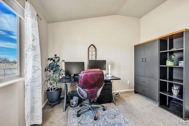 carpeted office featuring vaulted ceiling and baseboards