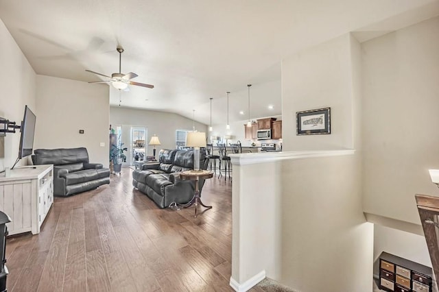 living room with a ceiling fan, lofted ceiling, and wood finished floors