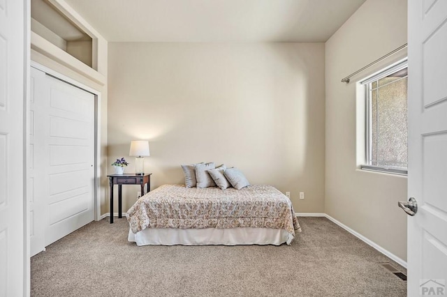 carpeted bedroom featuring baseboards and visible vents