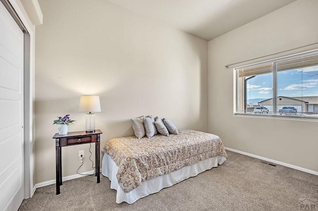 carpeted bedroom featuring baseboards, visible vents, and a closet