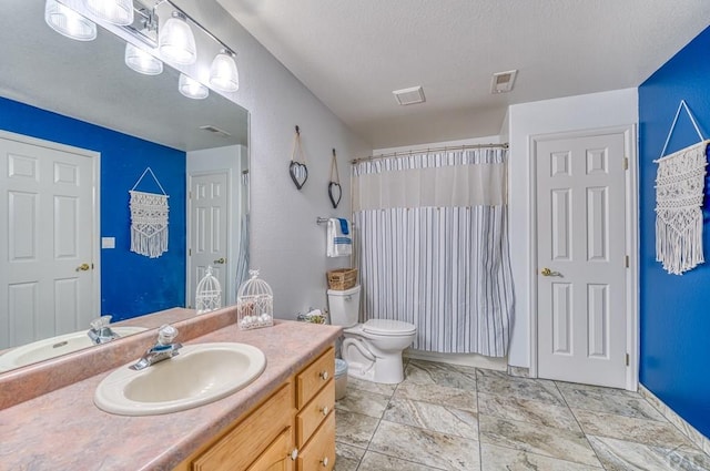 bathroom featuring curtained shower, visible vents, vanity, and toilet