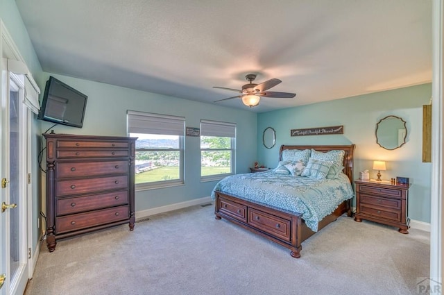 bedroom featuring light carpet, baseboards, and a ceiling fan