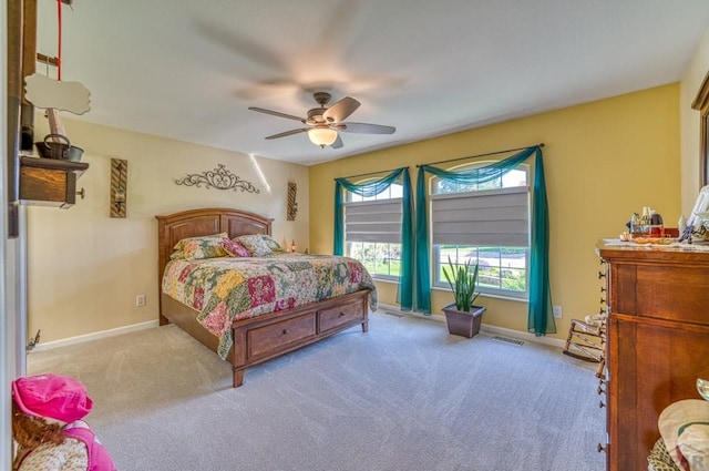 bedroom featuring a ceiling fan, light colored carpet, visible vents, and baseboards