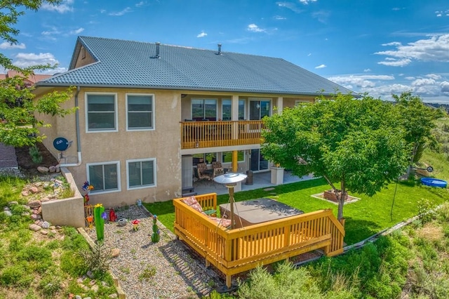 back of house with a yard, a patio, a tile roof, and stucco siding