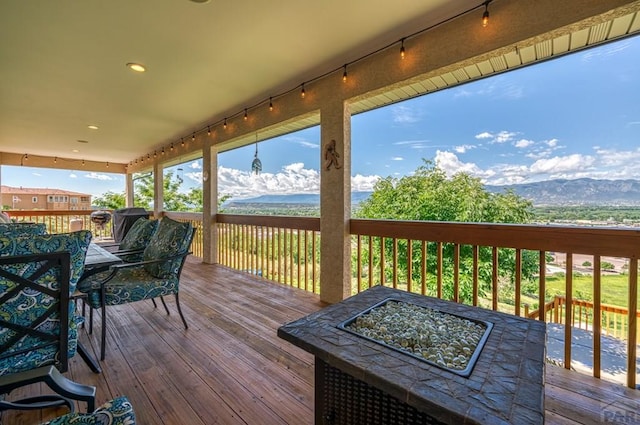 wooden terrace featuring outdoor dining area and a mountain view