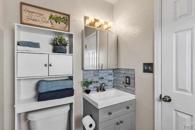 half bath with toilet, tasteful backsplash, and vanity