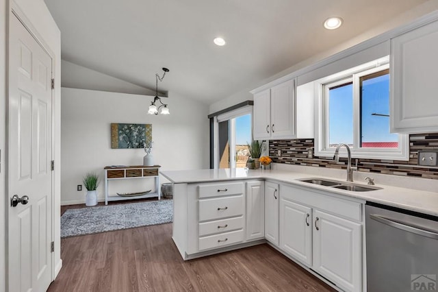 kitchen with hanging light fixtures, stainless steel dishwasher, a sink, and white cabinetry