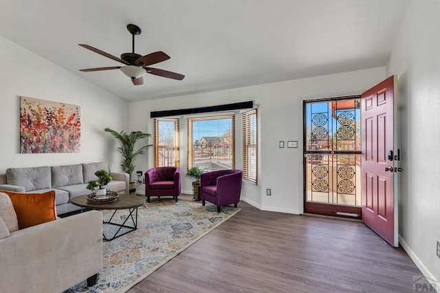 living area with vaulted ceiling, dark wood finished floors, a ceiling fan, and baseboards