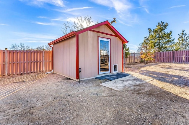 view of outbuilding with a fenced backyard and an outbuilding