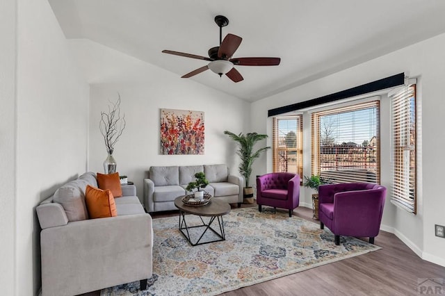 living room with ceiling fan, baseboards, vaulted ceiling, and wood finished floors