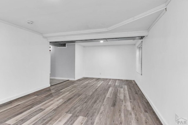 spare room with ornamental molding, wood finished floors, and baseboards