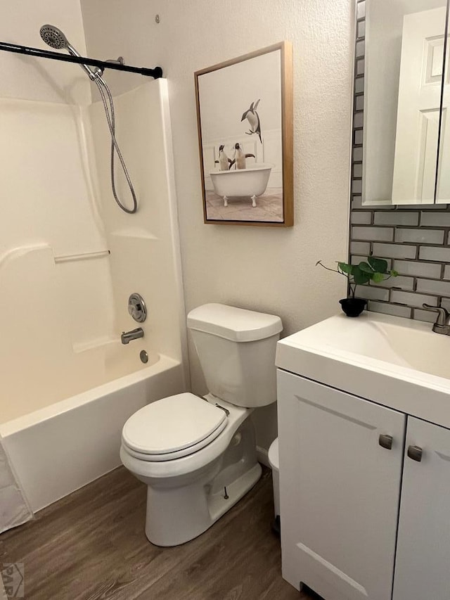 full bath featuring toilet, shower / bath combination, wood finished floors, and vanity