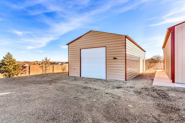 detached garage featuring fence