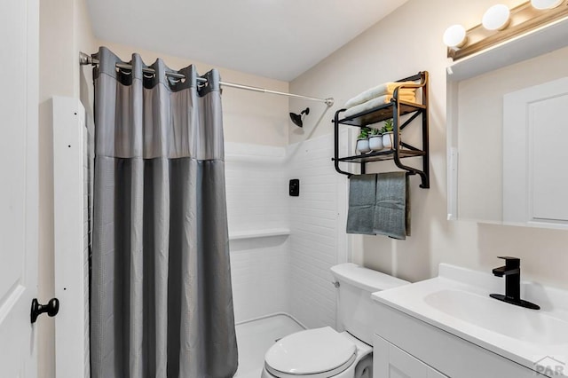 full bathroom featuring a stall shower, vanity, and toilet