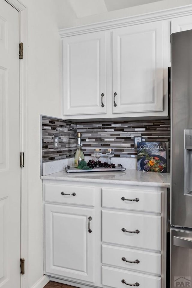 interior space featuring tasteful backsplash and stainless steel fridge