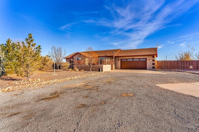 view of front of property with a garage, driveway, fence, and stucco siding