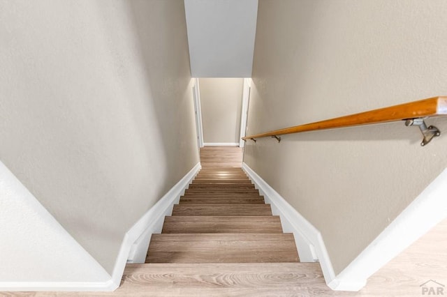 stairs featuring wood finished floors and baseboards