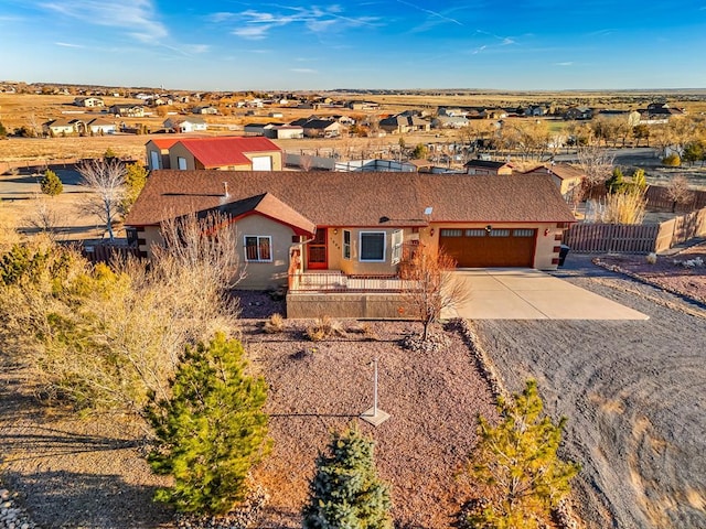 view of front of property with a garage, fence, concrete driveway, a residential view, and stucco siding