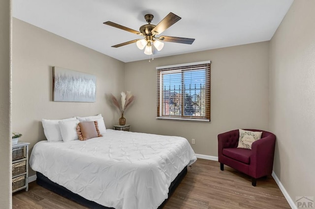 bedroom featuring dark wood-style flooring, ceiling fan, and baseboards