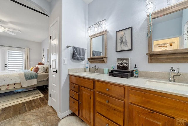 ensuite bathroom with double vanity, ceiling fan, a sink, and ensuite bathroom