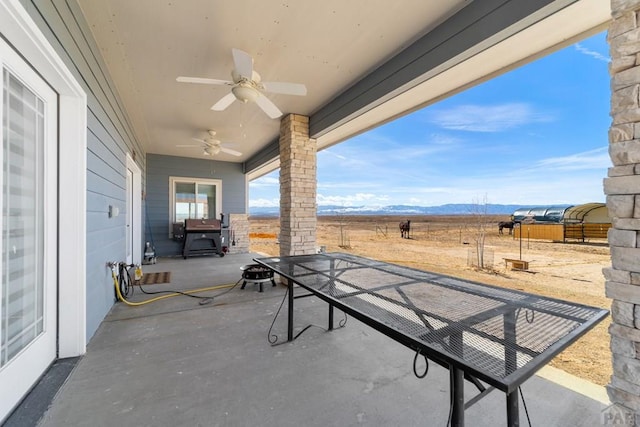 view of patio with a mountain view and a ceiling fan