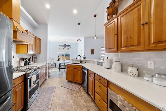 kitchen with stainless steel appliances, pendant lighting, light countertops, and a sink