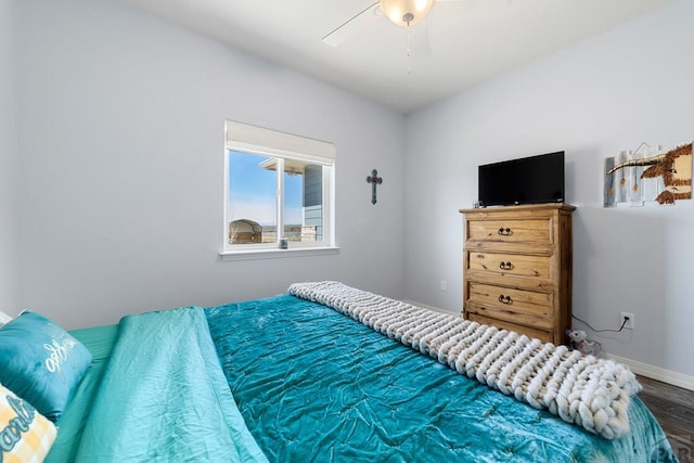 bedroom featuring wood finished floors, a ceiling fan, and baseboards