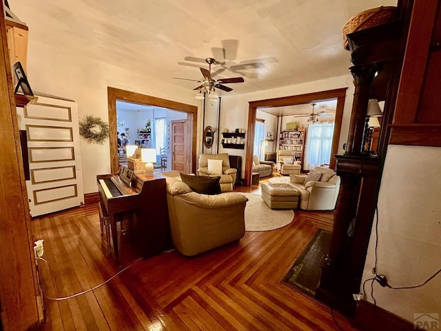 interior space with wood finished floors, a ceiling fan, and baseboards