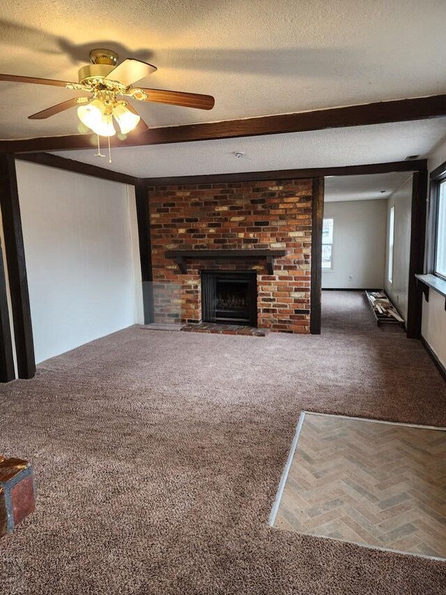 unfurnished living room with carpet floors, a fireplace, and a textured ceiling