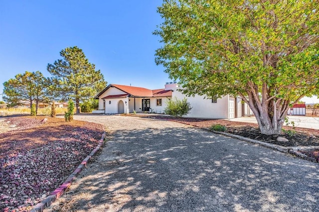 view of front of home with gravel driveway and stucco siding