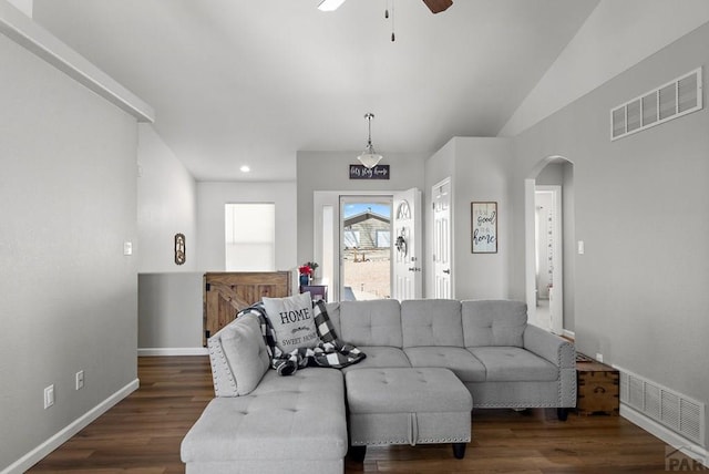 living area featuring arched walkways, wood finished floors, visible vents, and baseboards