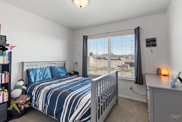 bedroom featuring light colored carpet and baseboards