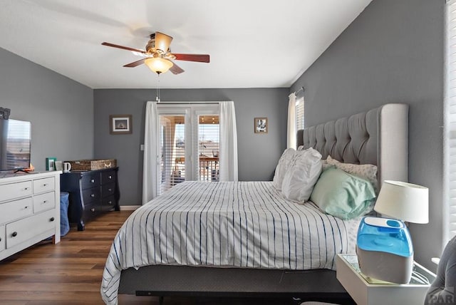 bedroom with baseboards, dark wood finished floors, a ceiling fan, and access to exterior