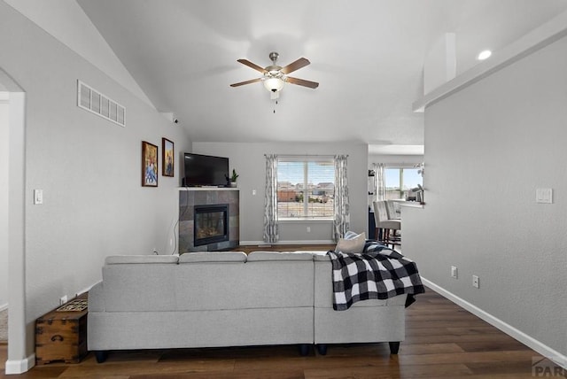 living area with baseboards, visible vents, dark wood finished floors, lofted ceiling, and a fireplace