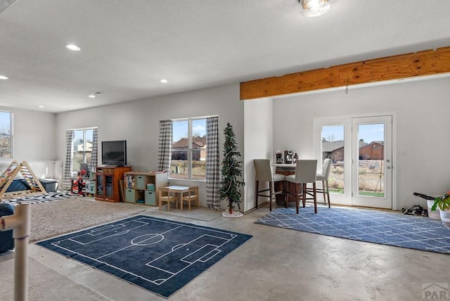 living area featuring recessed lighting, plenty of natural light, a textured ceiling, and concrete floors