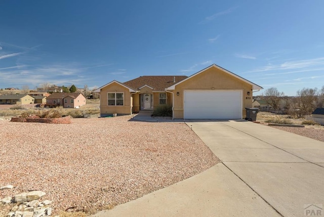 ranch-style home featuring an attached garage, concrete driveway, and stucco siding