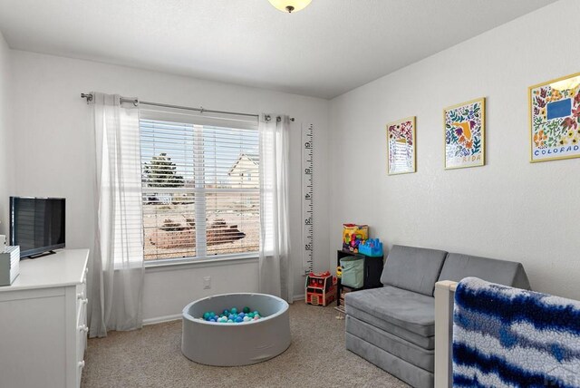 game room with baseboards and light colored carpet