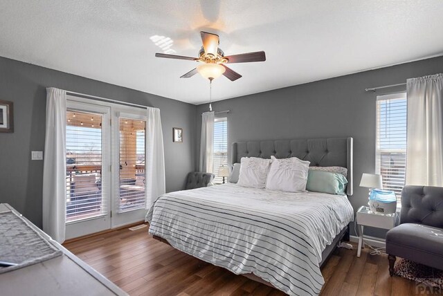 bedroom with access to exterior, ceiling fan, multiple windows, and wood finished floors