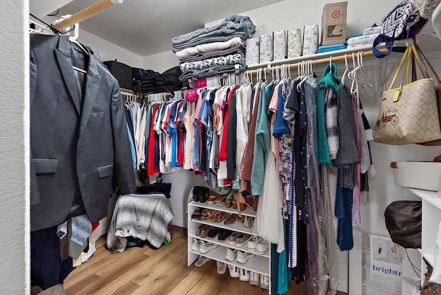 walk in closet with wood finished floors