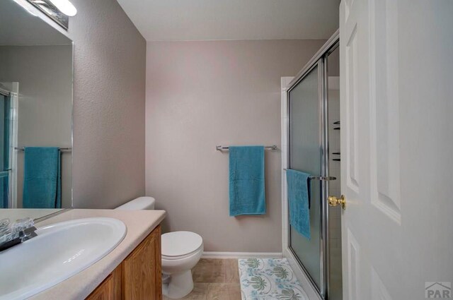 6292 Riverdale Dr, Colorado Springs, CO 80923 - full bathroom with vanity, an enclosed shower, and tile patterned flooring