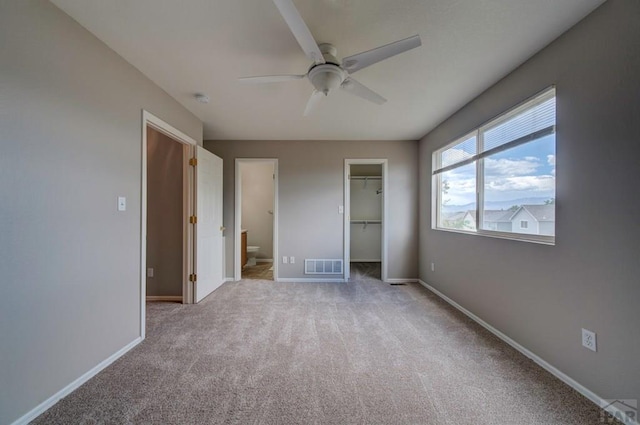 6292 Riverdale Dr, Colorado Springs, CO 80923 - unfurnished bedroom with carpet floors, a spacious closet, a ceiling fan, and connected bathroom