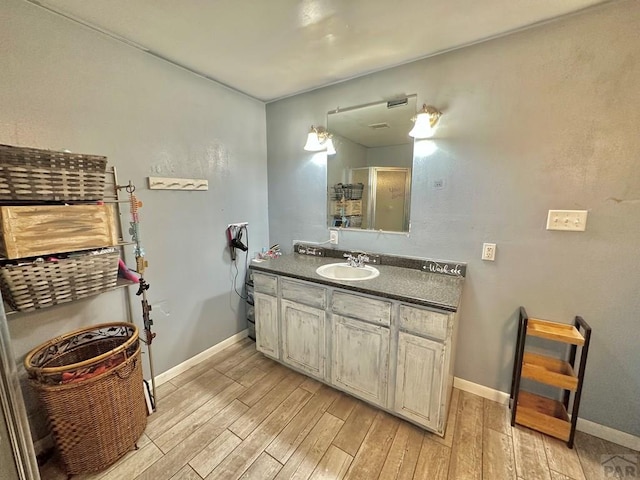 2 Kincaid Dr, Swink, CO 81077 - bathroom featuring wood finished floors, baseboards, and vanity