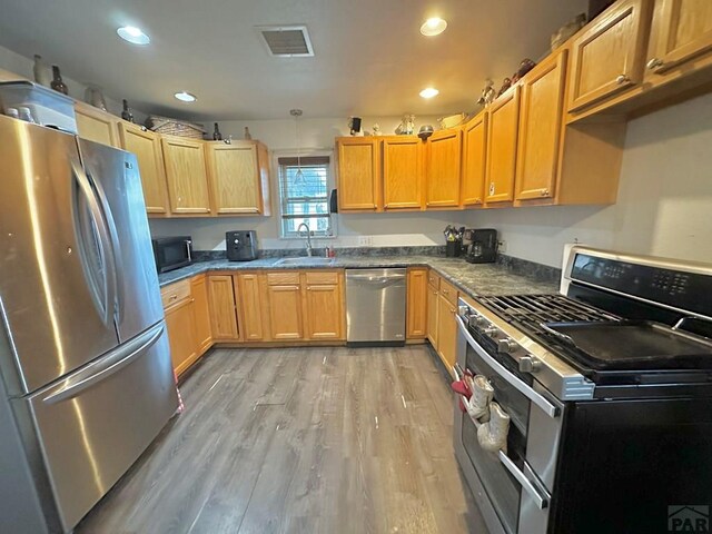 2 Kincaid Dr, Swink, CO 81077 - kitchen featuring appliances with stainless steel finishes, a sink, light wood finished floors, recessed lighting, and dark countertops
