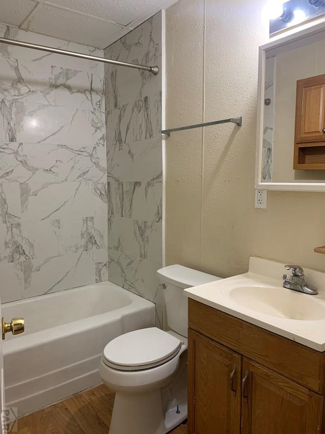 bathroom with toilet, vanity, wood finished floors, and bathing tub / shower combination