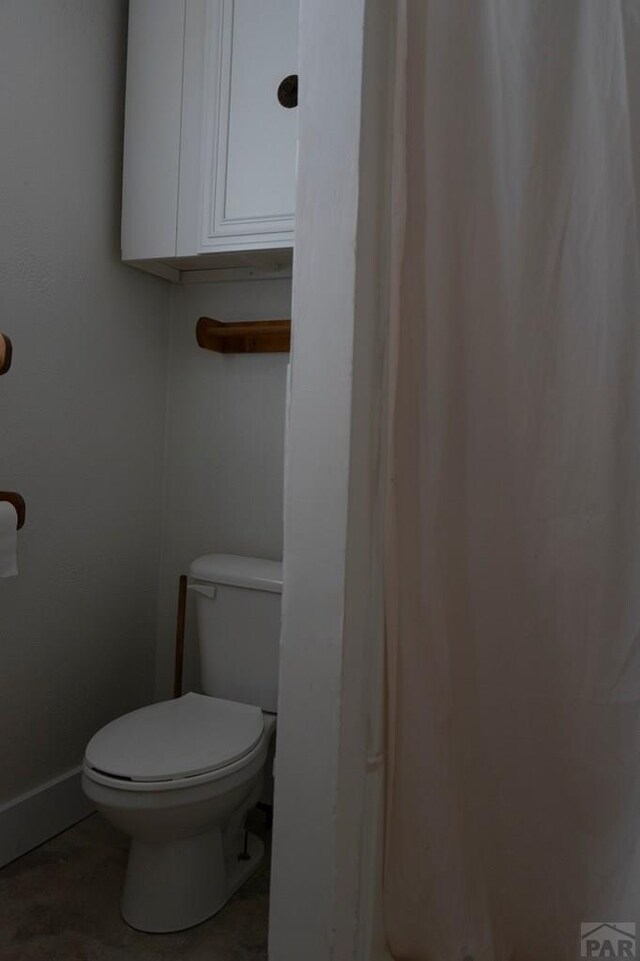 bathroom with toilet and baseboards